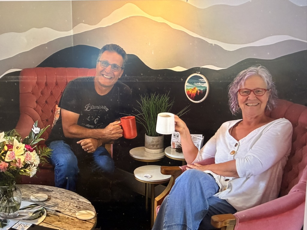 A member and her match laughing in armchairs with coffee mugs